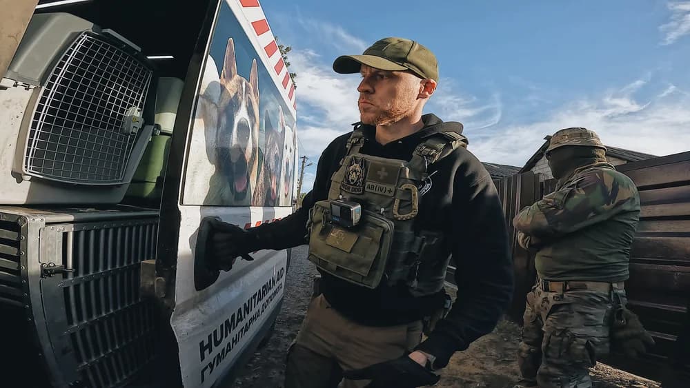 A volunteer beside an animal evacuation van with transport crates in Kupiansk, Ukraine
